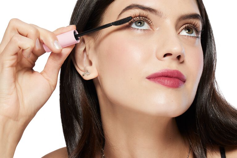 Close-up of a person applying mascara with a pink Mary Kay Great Heights Waterproof wand.