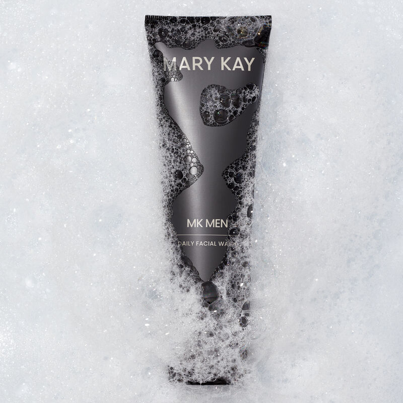 Bottle of MKMen Daily Facial Wash immersed in foamy bubbles 