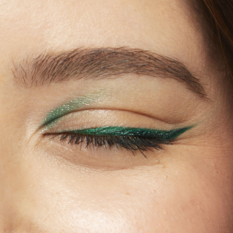 Close up of medium-skinned model wearing special-edition Mary Kay Waterproof Eyeliner in shade Emerald in a winged shape image number null
