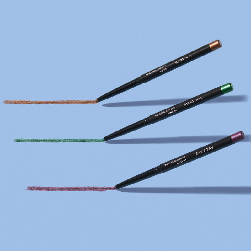 Special-edition Mary Kay Waterproof Eyeliner in shades Copper, Emerald and Amethyst, drawing product rubs against a light blue background image number null