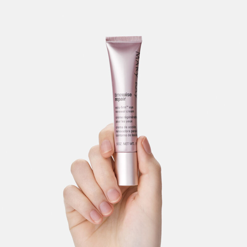 A hand holding atube of TimeWise Repair Volu-Firm Eye Renewal Cream from Mary Kay