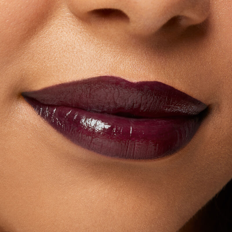 Close up of medium skinned model&rsquo;s lips in a closed smile wearing Mary Kay Supreme Hydrating Lipstick in shade Black Cherry.